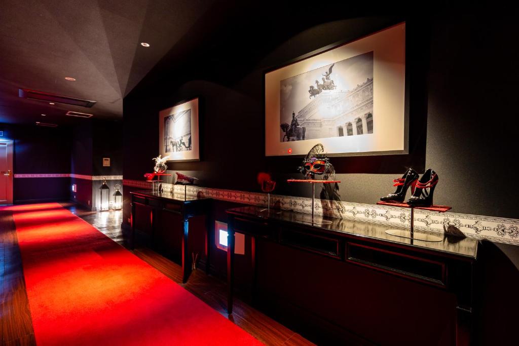 Cette chambre dispose d'un tapis rouge et d'un bar avec des chaussures. dans l'établissement Hotel LOVE MODERN, à Kitakyūshū 65 autres photos