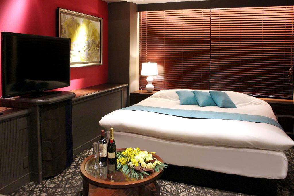 une chambre avec un lit et une télévision à écran plat dans l'établissement Hotel LOVE MODERN, à Kitakyūshū