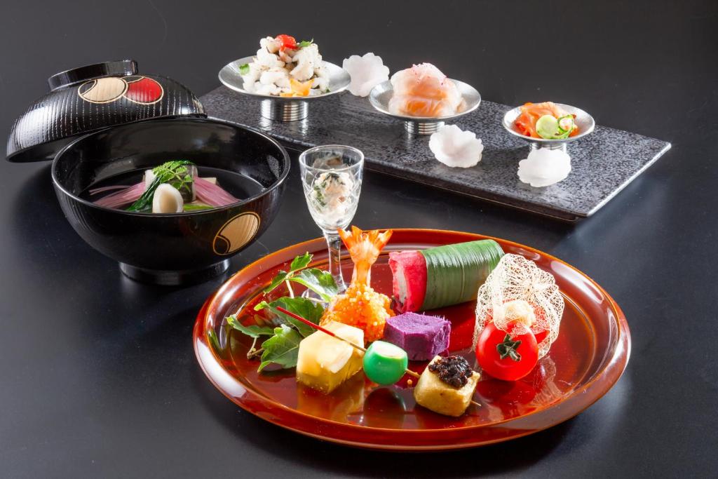 une assiette de nourriture sur une table avec des assiettes de nourriture dans l'établissement Muromachi Yutone Kyokoyado, à Kyoto