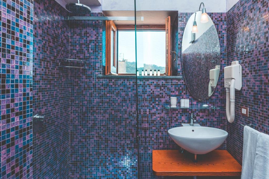 une salle de bain avec un lavabo et un miroir dans l'établissement Lubra Casa Relax, à Massa Lubrense 50 autres photos