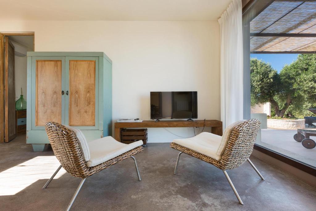 - un salon avec deux chaises et un bureau dans l'établissement Villa Sofia by Perle di Puglia, à Carovigno