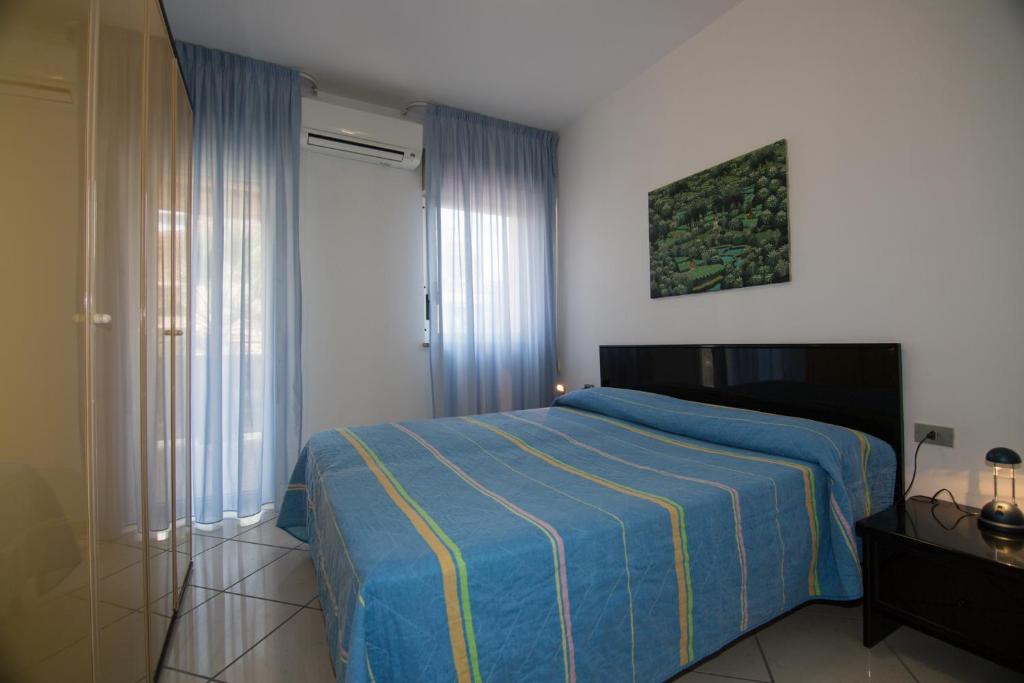 - une chambre dotée d'un lit avec une couverture bleue et jaune dans l'établissement Appartamenti La Mer, à San Benedetto del Tronto