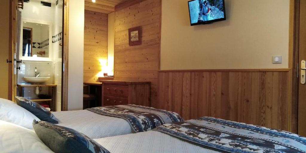 - une chambre avec 2 lits et une télévision murale dans l'établissement Le Dôme, à Tignes