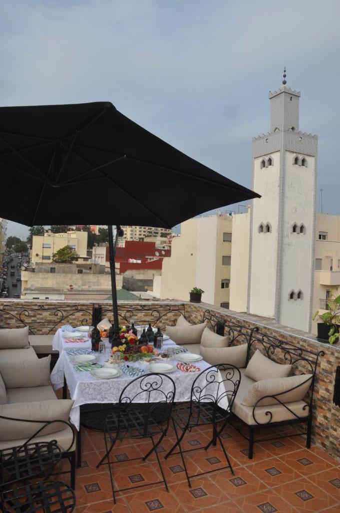 - une table et des chaises sous un parasol sur la terrasse dans l'établissement Riad Dar Mesouda, à Tanger