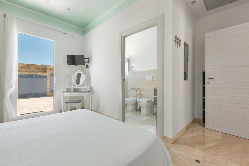 une chambre blanche avec un lit et une salle de bain dans l'établissement Villa Albarosa by Perle di Puglia, à Ruffano