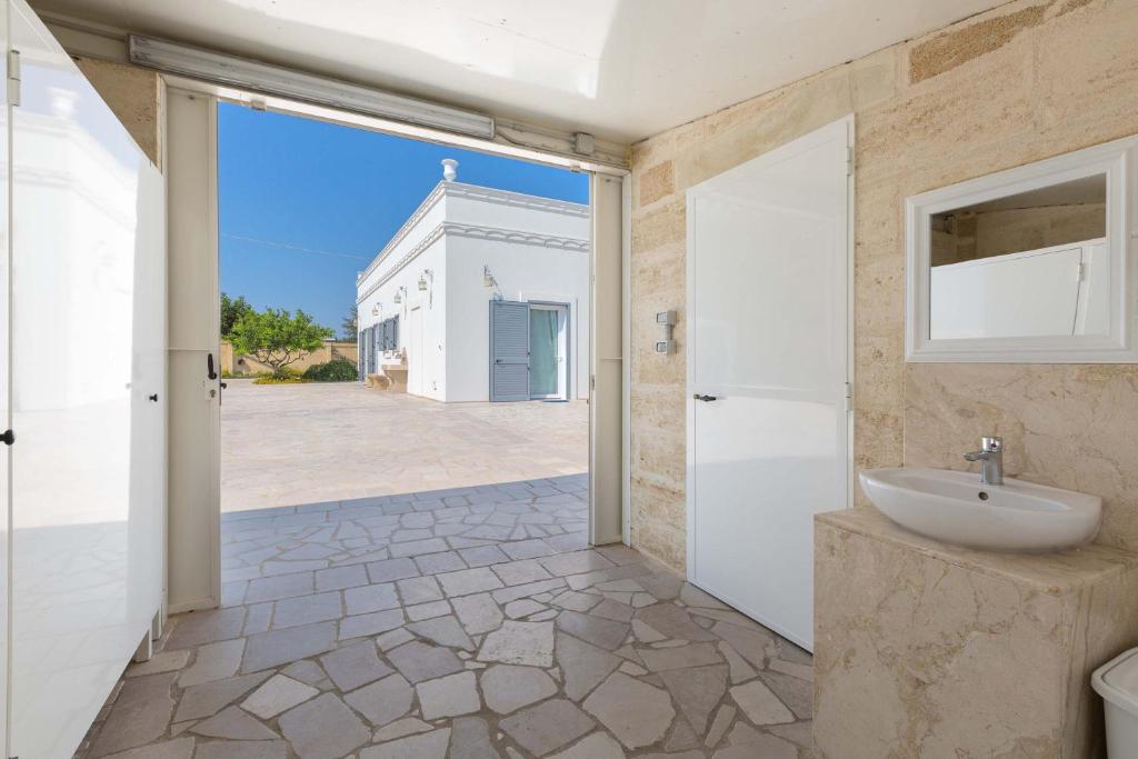 La salle de bains est pourvue d'un lavabo et d'une grande porte. dans l'établissement Villa Albarosa by Perle di Puglia, à Ruffano 42 autres photos