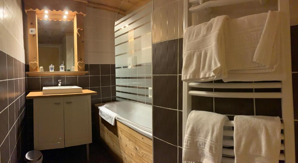 une salle de bain avec une baignoire, un lavabo et un miroir dans l'établissement Alp'azur, à L'Alpe-d'Huez
