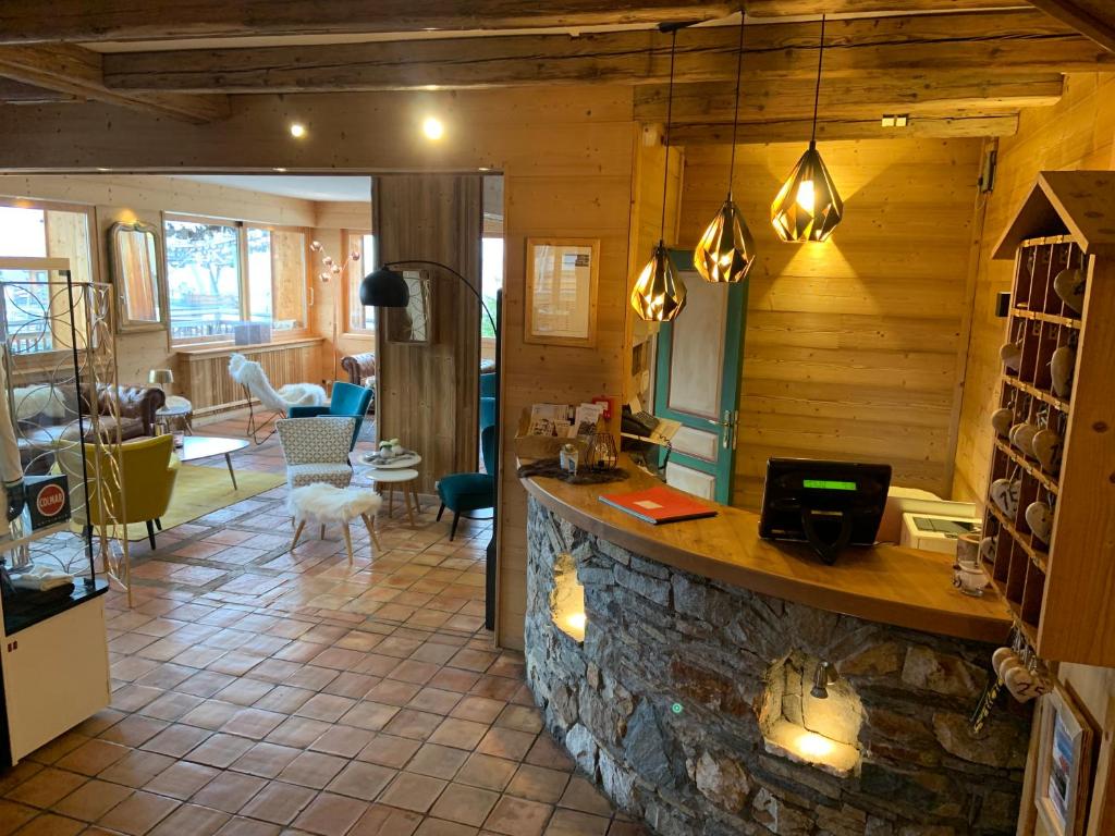 - un salon avec un bar en pierre dans une cabane en rondins dans l'établissement Alp'azur, à L'Alpe-d'Huez