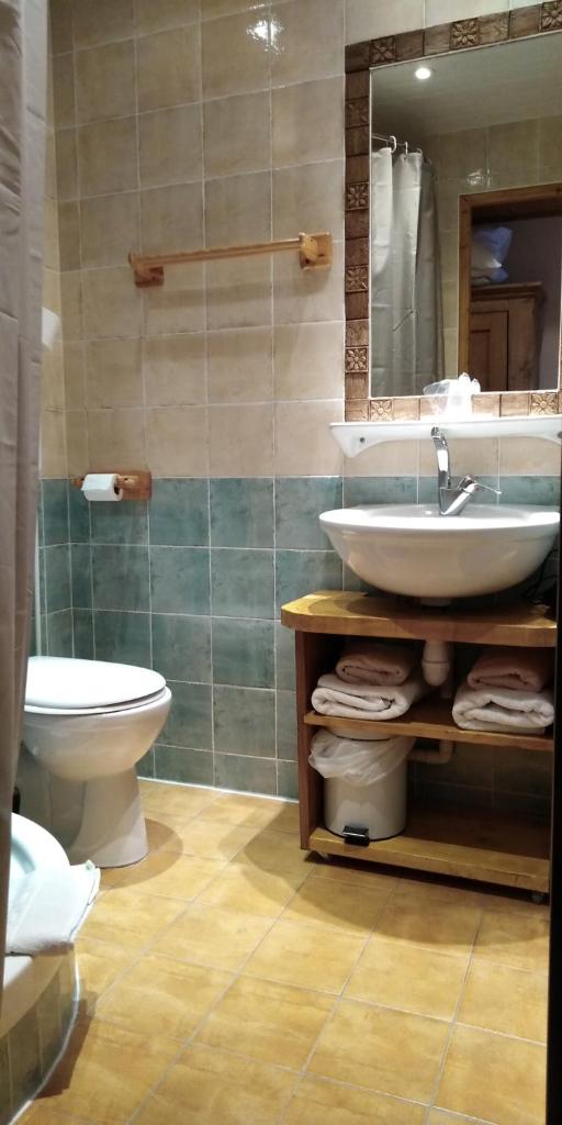une salle de bain avec un lavabo, des toilettes et un miroir dans l'établissement Le Dôme, à Tignes