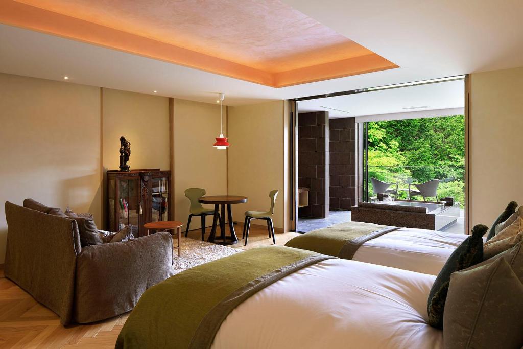une chambre d'hôtel avec deux lits, une table et des chaises dans l'établissement THE HIRAMATSU HOTELS & RESORTS SENGOKUHARA HAKONE, à Hakone