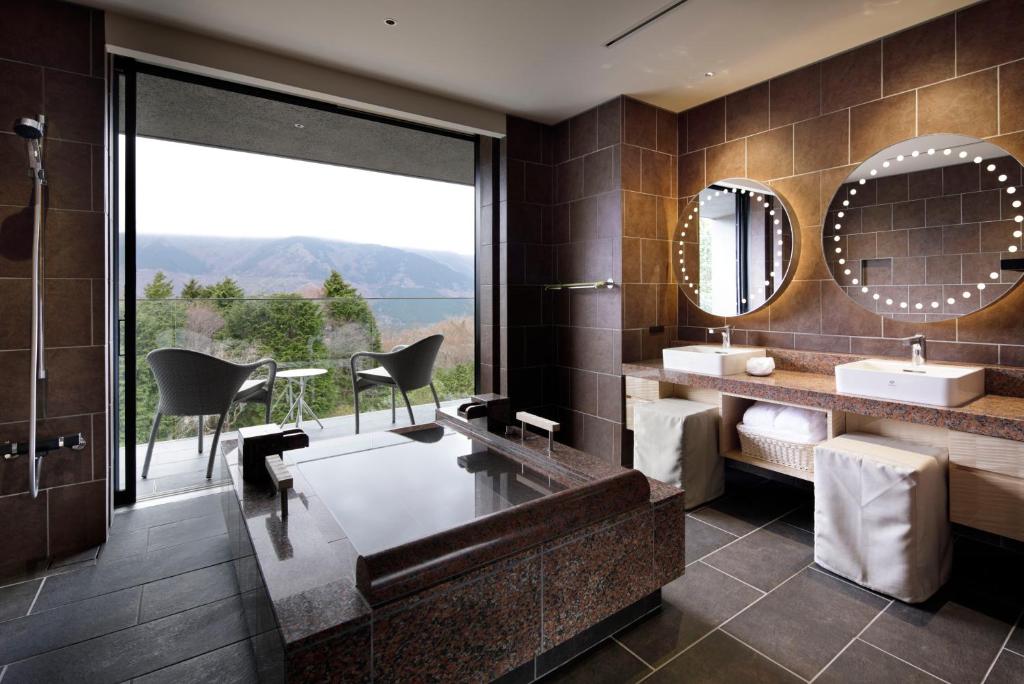 une salle de bain avec une baignoire, un lavabo et un miroir dans l'établissement THE HIRAMATSU HOTELS & RESORTS SENGOKUHARA HAKONE, à Hakone