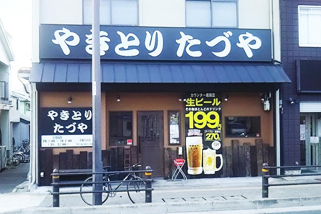 un magasin avec des inscriptions asiatiques sur la façade d'un bâtiment dans l'établissement Hotel Route One, à Osaka