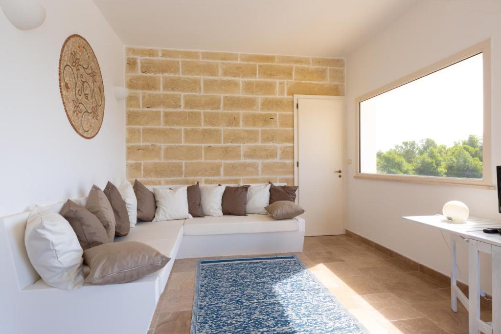 - un salon avec un canapé blanc et un mur en briques dans l'établissement VILLA BIANCA con piscina e vista mare, à Gagliano del Capo 27 autres photos