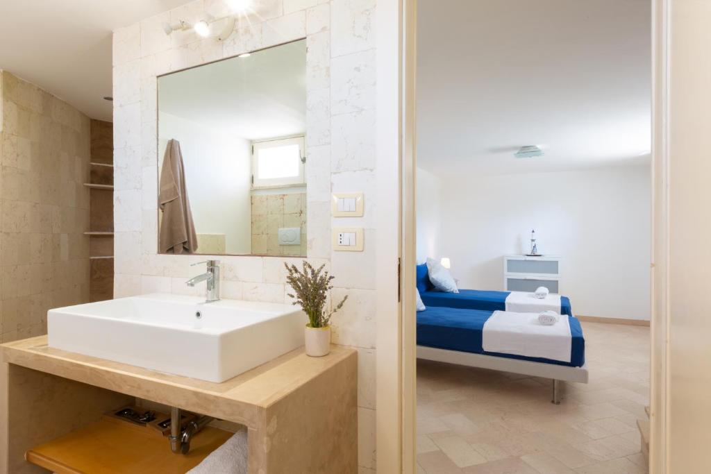 une salle de bain avec un lavabo et un lit dans l'établissement VILLA BIANCA con piscina e vista mare, à Gagliano del Capo