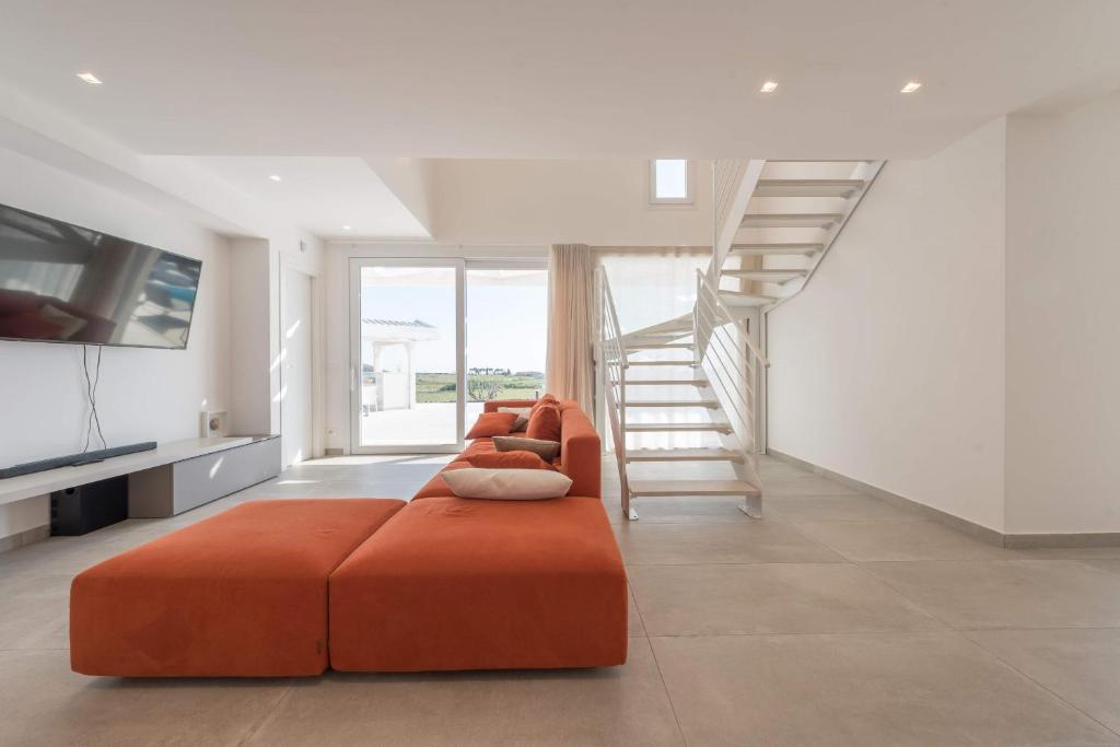 - un salon avec un canapé orange et un escalier dans l'établissement Villa White - IsulaTravel, à Modica