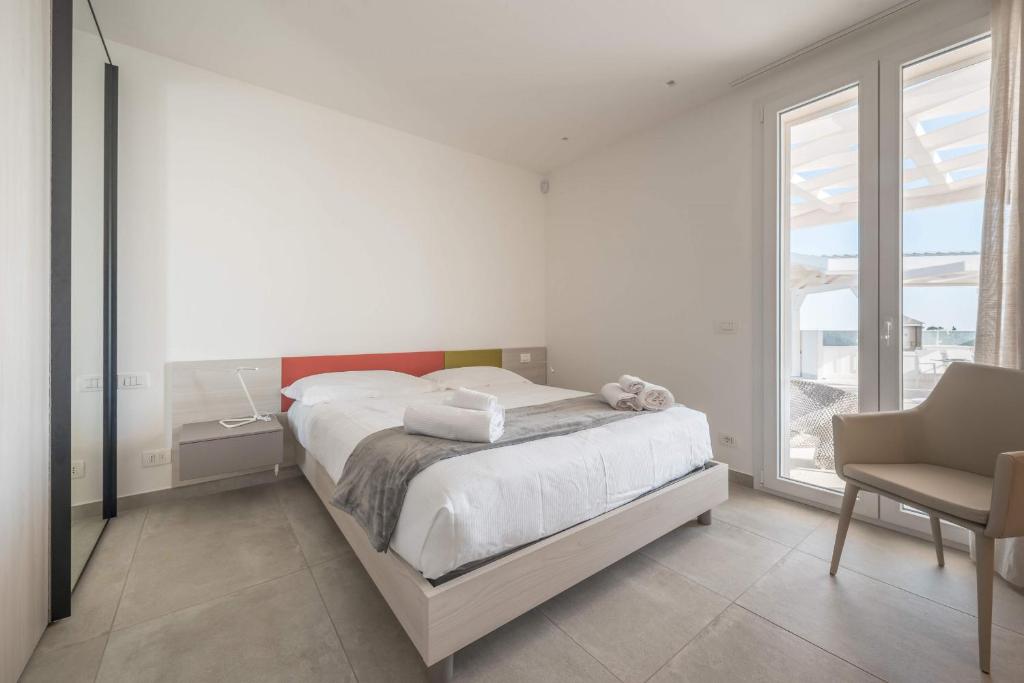 une chambre blanche avec un lit et une chaise dans l'établissement Villa White - IsulaTravel, à Modica 29 autres photos