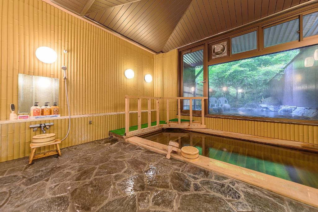 une chambre avec une piscine dans une maison dans l'établissement 료칸 여명 旅館 黎明 Ryokan Reimei, à Yufu