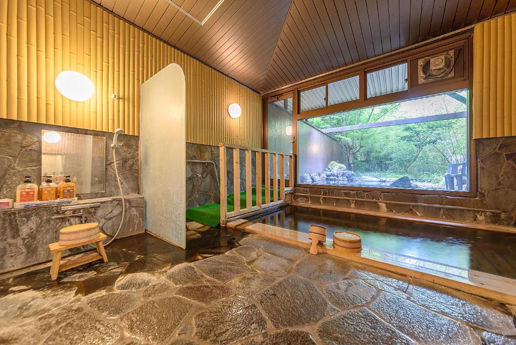 - une salle de bains avec une piscine dans une maison dans l'établissement 료칸 여명 旅館 黎明 Ryokan Reimei, à Yufu