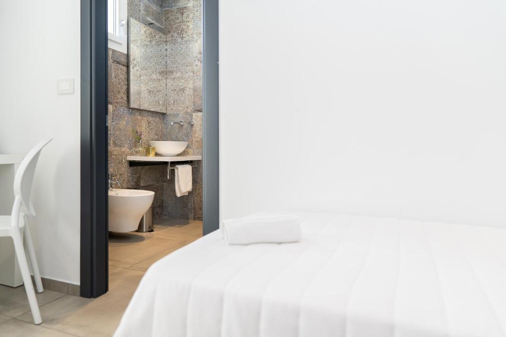 une chambre avec un lit blanc et une salle de bain dans l'établissement Hotel Abc, à Cervia
