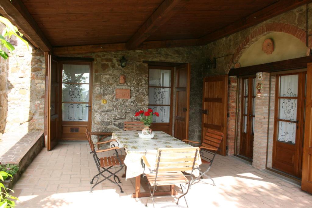 une terrasse avec une table et des chaises dans une maison dans l'établissement PODERE CAPANNE, à Sinalunga