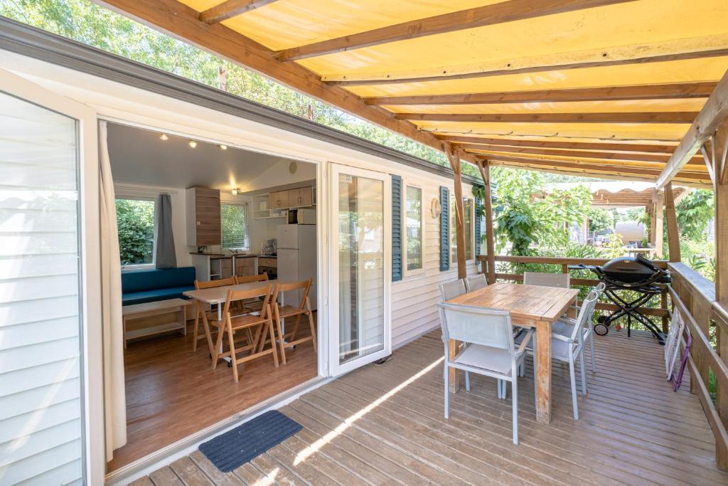 un patio avec une table et des chaises sur une terrasse dans l'établissement Camping Le Parc des Monges, à Auribeau-sur-Siagne