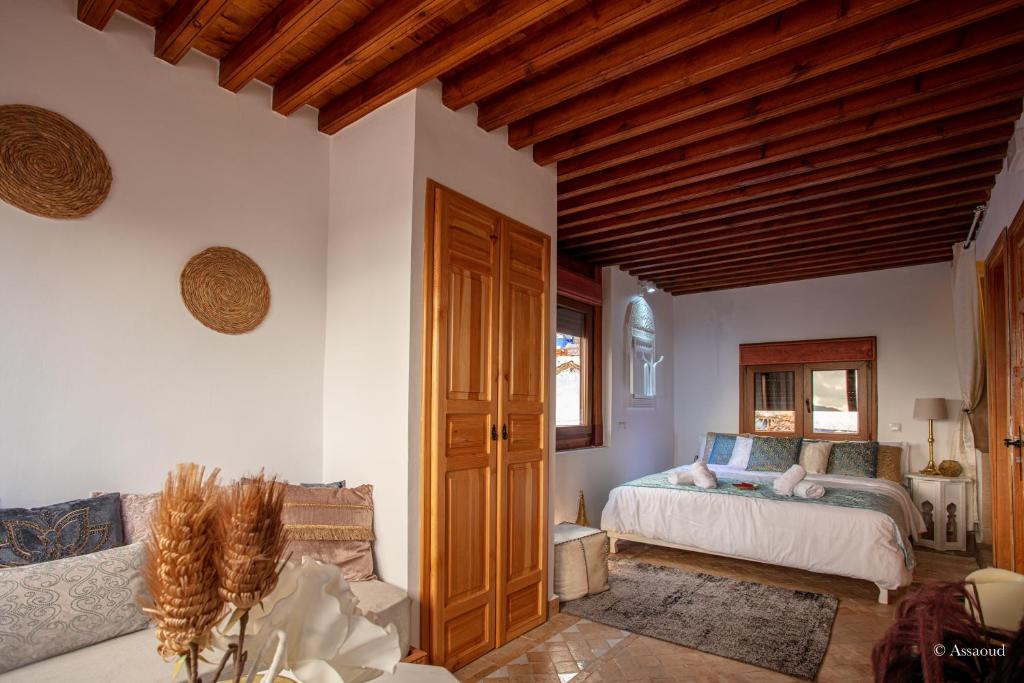 une chambre avec un lit et un plafond en bois dans l'établissement Riad Nila, à Chefchaouen