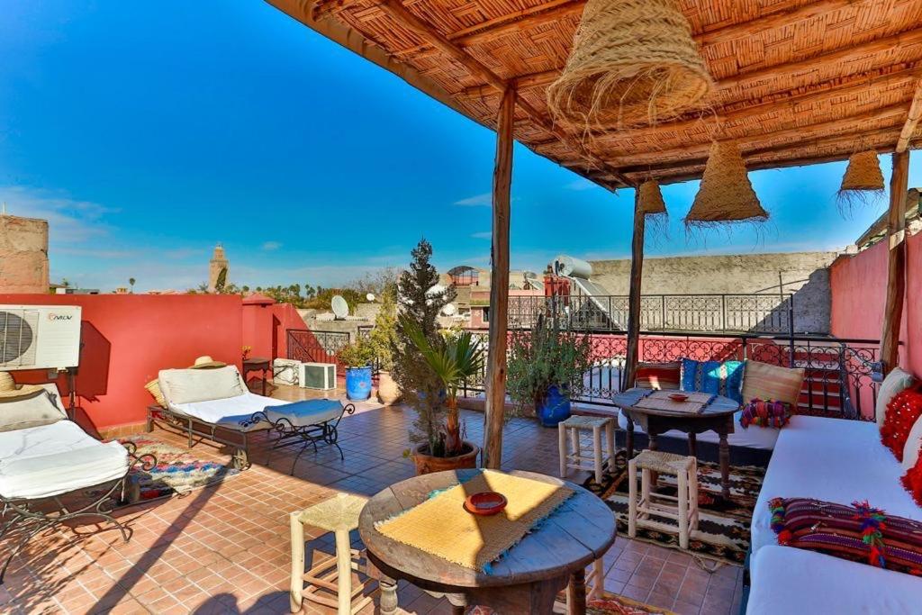 un patio avec tables et chaises sur un balcon dans l'établissement Riad Rose Meryam, à Marrakech