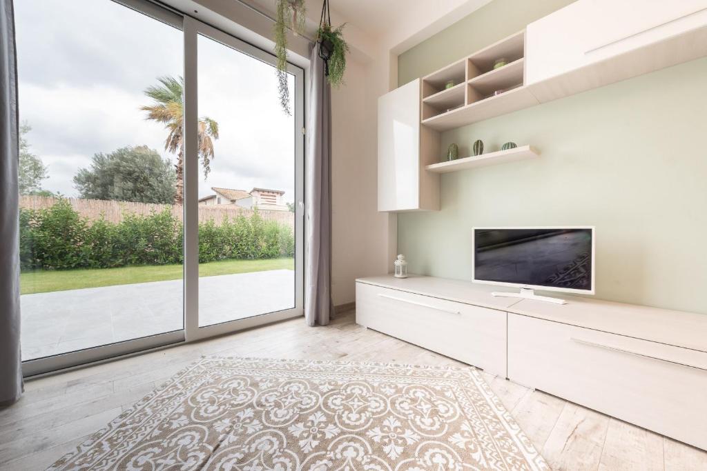 un salon avec une télévision et une grande fenêtre dans l'établissement Villa Emanuela - IsulaTravel, à Ispica