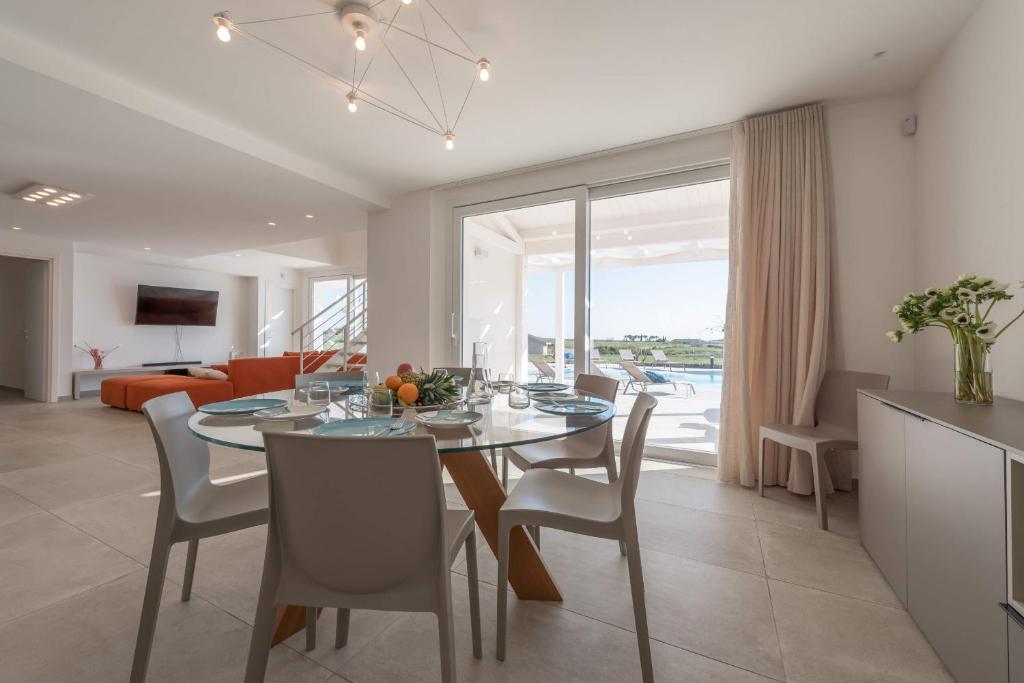 une salle à manger et un salon avec une table et des chaises dans l'établissement Villa White - IsulaTravel, à Modica