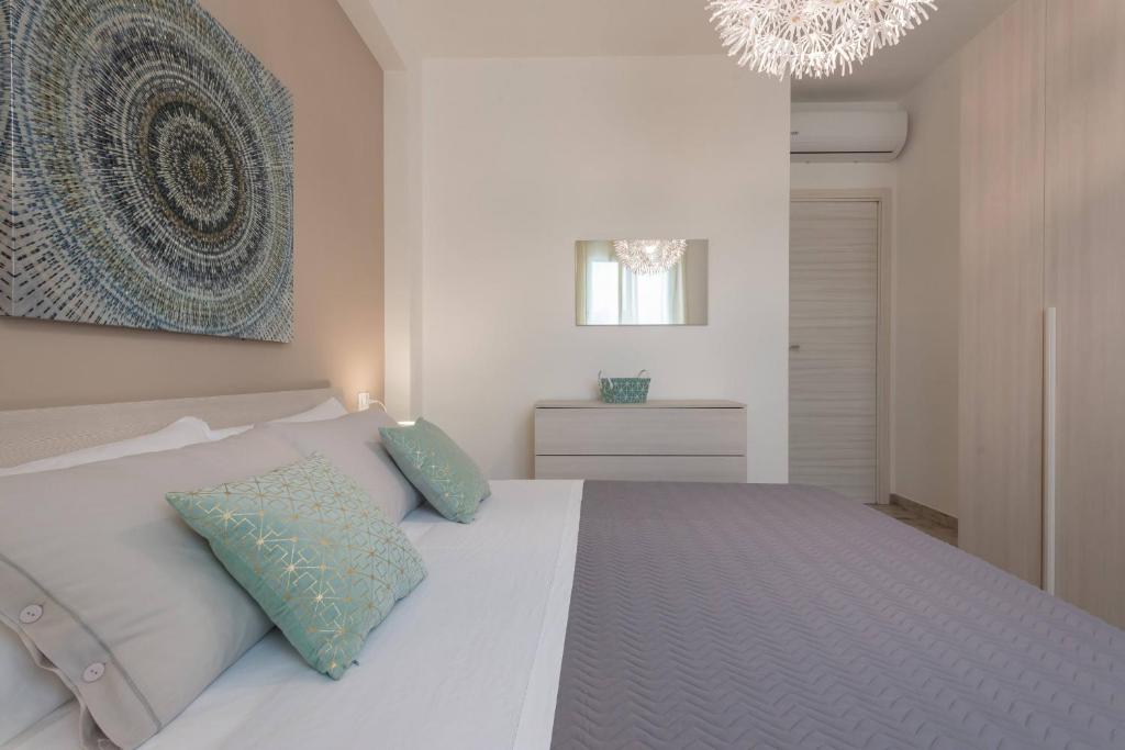 - une chambre avec un lit blanc et un lustre dans l'établissement Villa Emanuela - IsulaTravel, à Ispica 34 autres photos