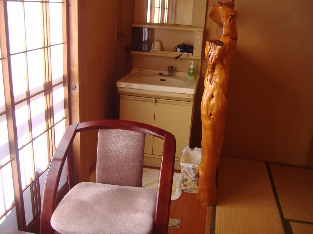une chaise en bois dans une cuisine avec évier dans l'établissement Ishibu-so, à Matsuzaki