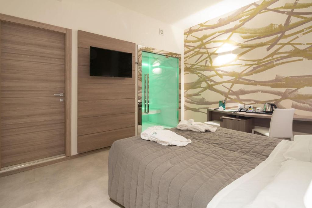 une chambre avec un lit, un bureau et une télévision dans l'établissement Hotel Iris Jesolo, à Lido di Jesolo