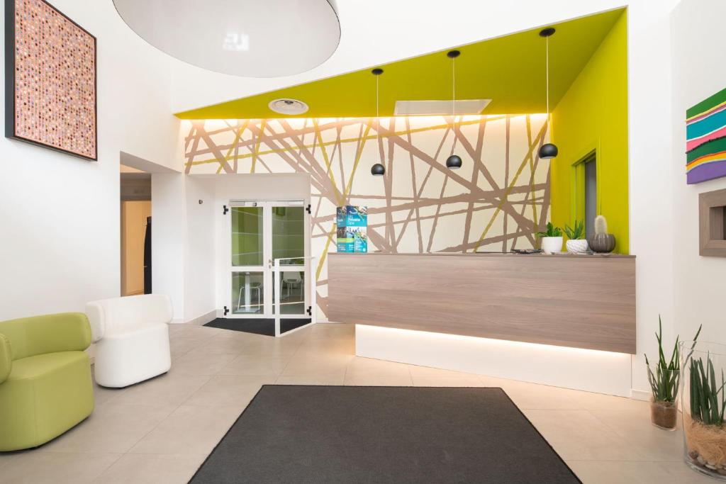 - un salon avec un mur jaune et un canapé dans l'établissement Hotel Iris Jesolo, à Lido di Jesolo