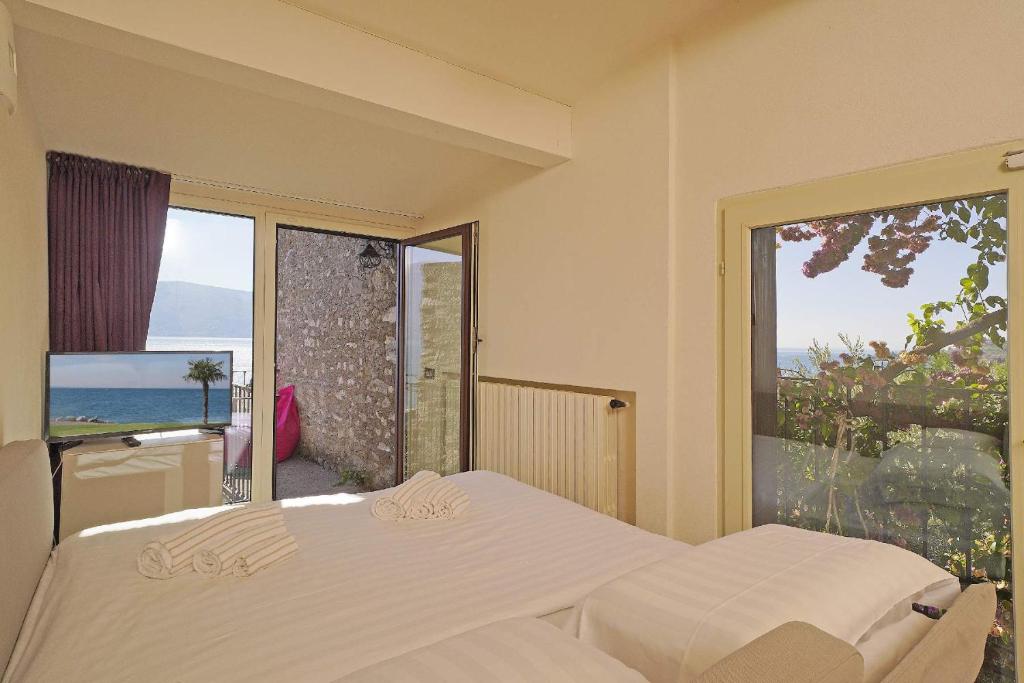 une chambre avec deux lits et une vue sur l'océan dans l'établissement Villa Rachele: stunning luxury villa in centre Gargnano with private pool and breathtaking views, à Gargnano 55 autres photos