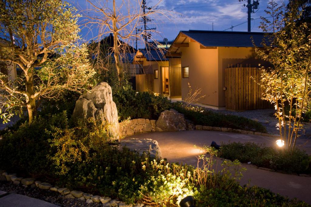 - un jardin la nuit avec des lumières devant une maison dans l'établissement Migiwaya, à Yaizu