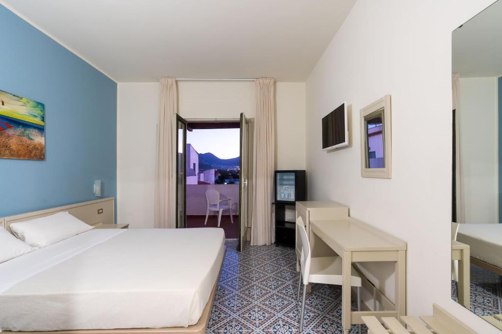 une chambre d'hôtel avec un lit et un bureau dans l'établissement Saracen Sands Hotel & Congress Centre - Palermo, à Isola delle Femmine