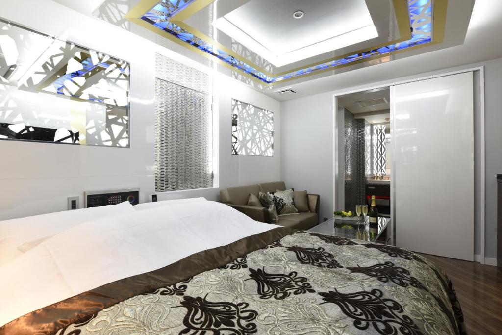 une chambre avec un grand lit et un canapé dans l'établissement HOTEL W-PARTY-W GROUP HOTELS and RESORTS-, à Kawaguchi 91 autres photos