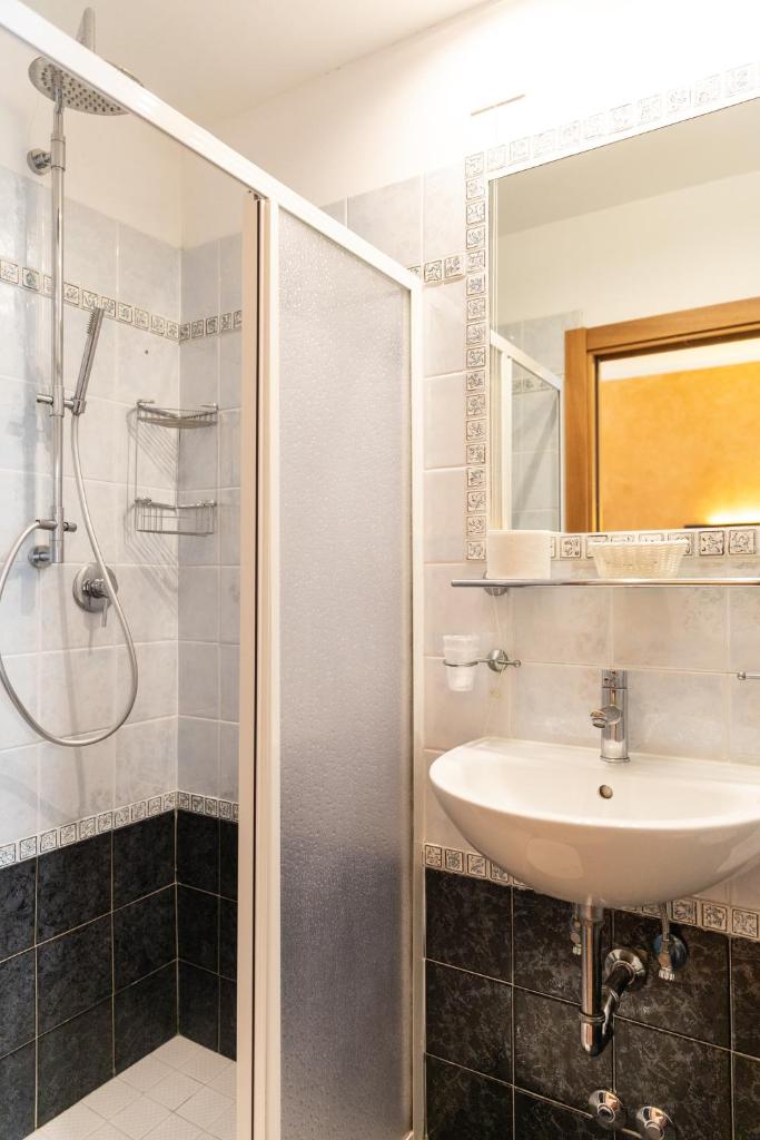 une salle de bain avec un lavabo et une douche dans l'établissement Hotel Verdi, à Lido di Jesolo
