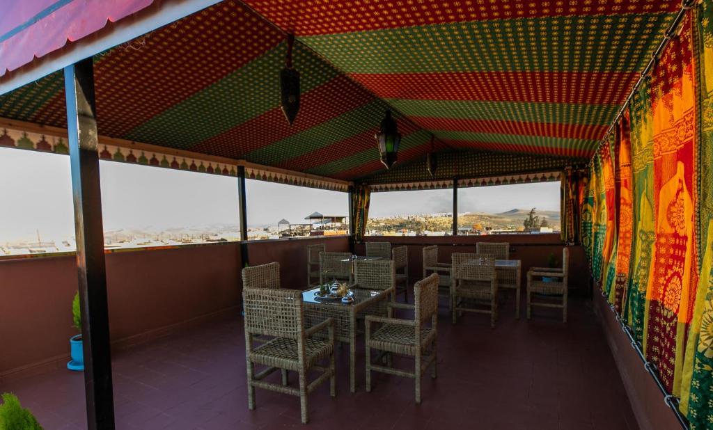 un restaurant avec des tables et des chaises sur un balcon dans l'établissement Dar Layali Fez, à Fès