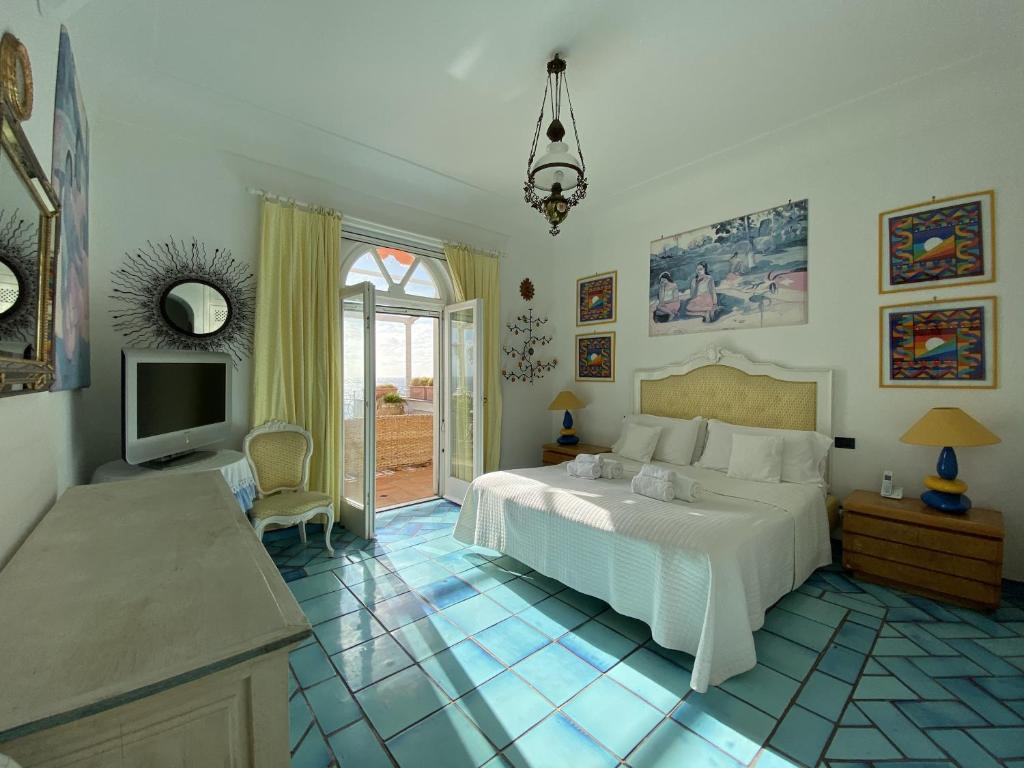 une chambre avec un lit et une télévision dans l'établissement Villa Teste di Moro, à Capri