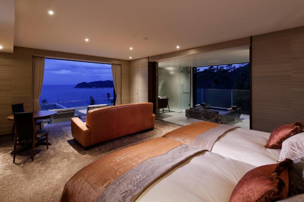 - une chambre avec un grand lit et une vue sur l'océan dans l'établissement THE HIRAMATSU HOTELS & RESORTS ATAMI, à Atami