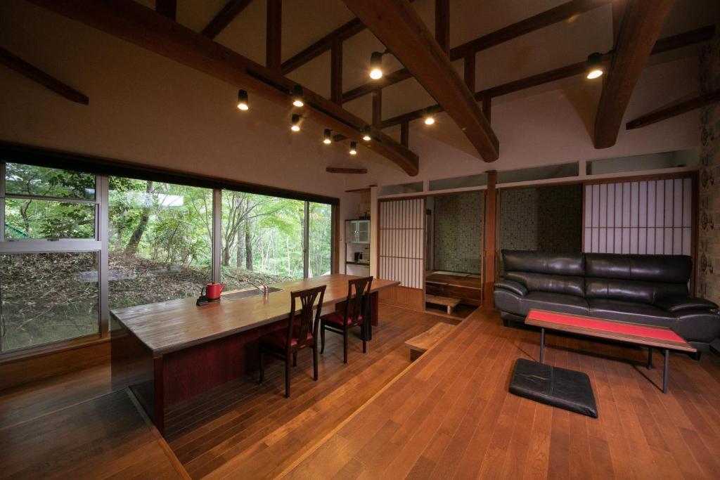 un salon avec une table et un canapé en cuir dans l'établissement Innter Hill Tsubasa Yufuin, à Yufu