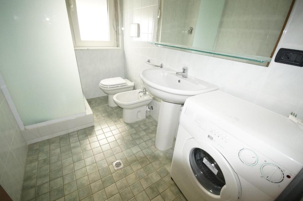 une salle de bain avec un lavabo et une machine à laver dans l'établissement Appartamenti La Mer, à San Benedetto del Tronto