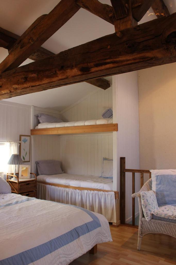 - une chambre avec 2 lits superposés et une chaise dans l'établissement Charoul'Hôtes Gîtes et roulotte insolite, à Saint-André-sur-Sèvre