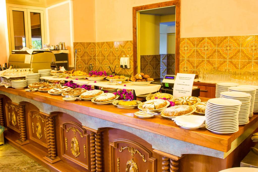 - un buffet avec des assiettes et des bols de nourriture sur une table dans l'établissement Taormina Park Hotel, à Taormine