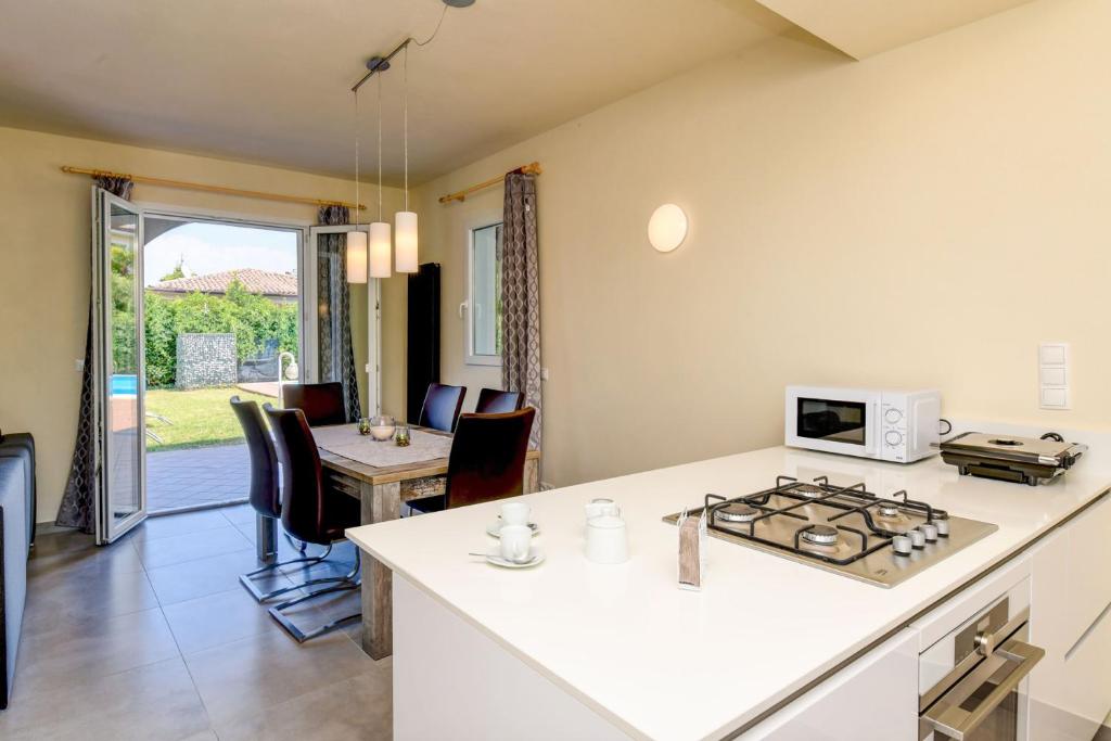 une cuisine et un salon avec une cuisinière et un four dans l'établissement Villa Sole, à Manerba del Garda