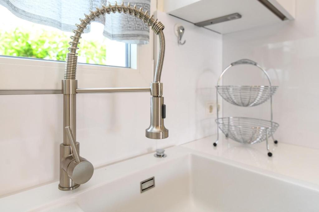 - un évier de cuisine avec un robinet à côté d'une fenêtre dans l'établissement Villa Sole, à Manerba del Garda