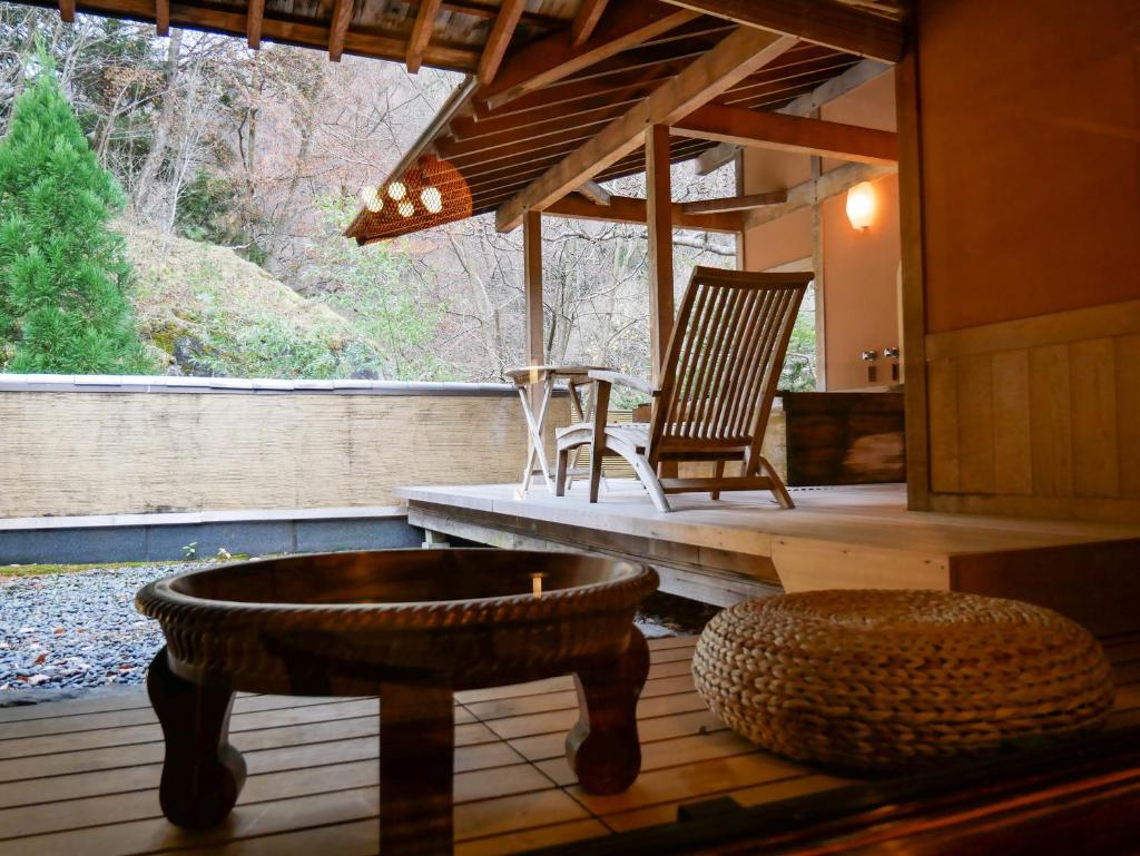 une terrasse couverte avec un banc, une chaise et une table dans l'établissement Myojinkan, à Matsumoto