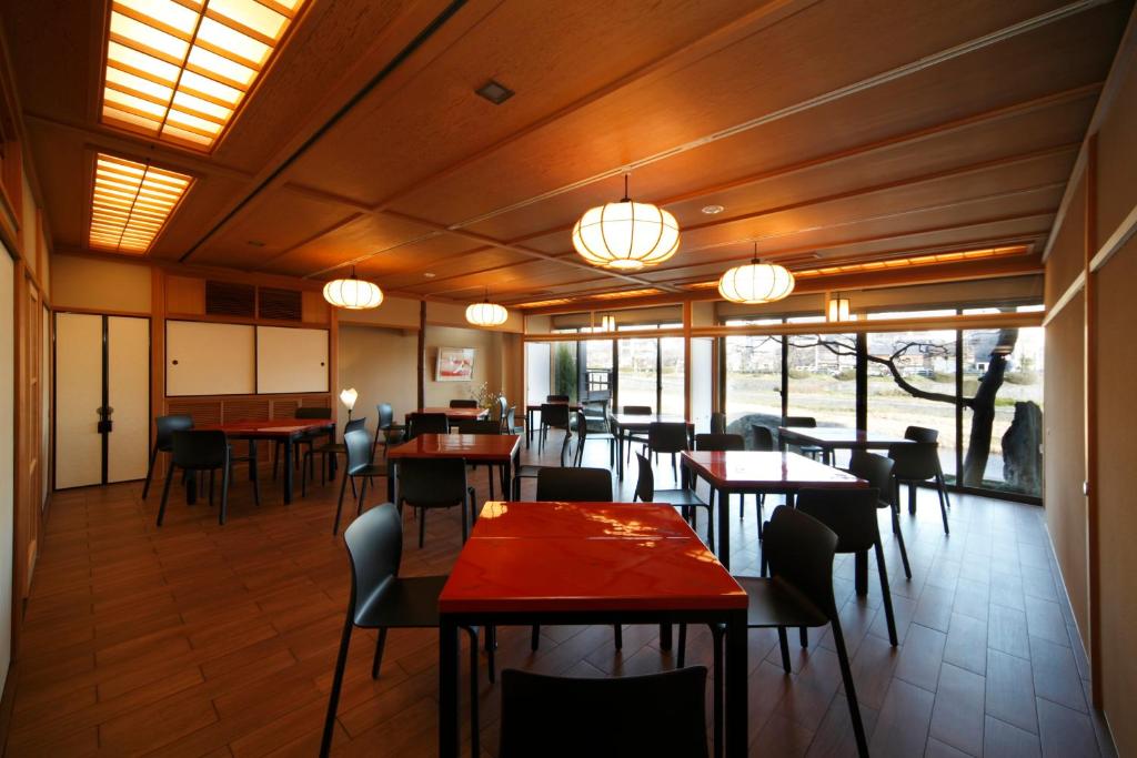 une salle à manger avec tables, chaises et fenêtres dans l'établissement Tazuru, à Kyoto 7 autres photos