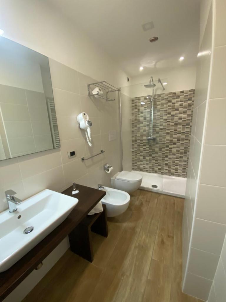 une salle de bain avec un lavabo, des toilettes et une douche dans l'établissement La Porta del Sole Hotel & Village, à San Ferdinando